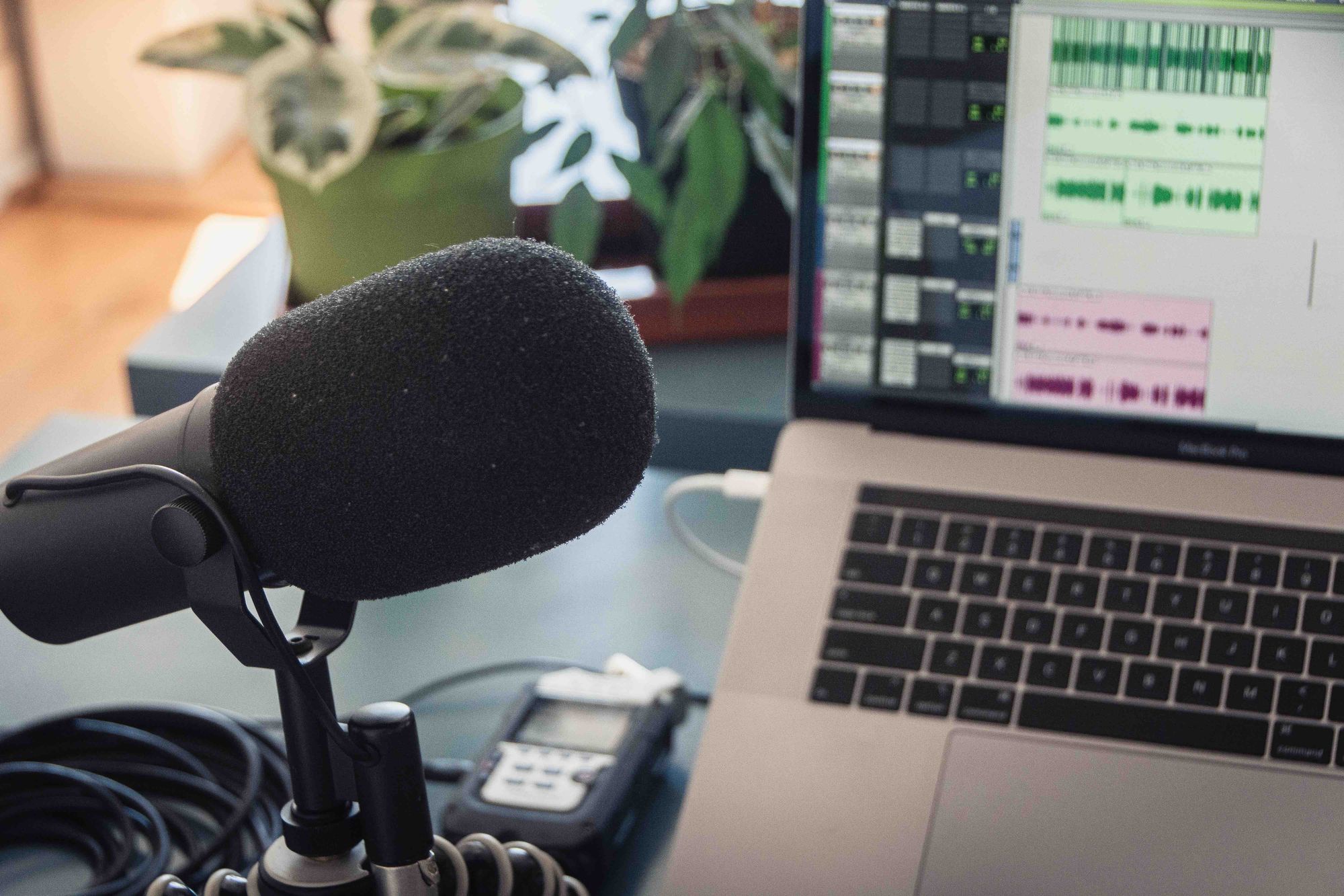 A microphone and a laptop on a desk.