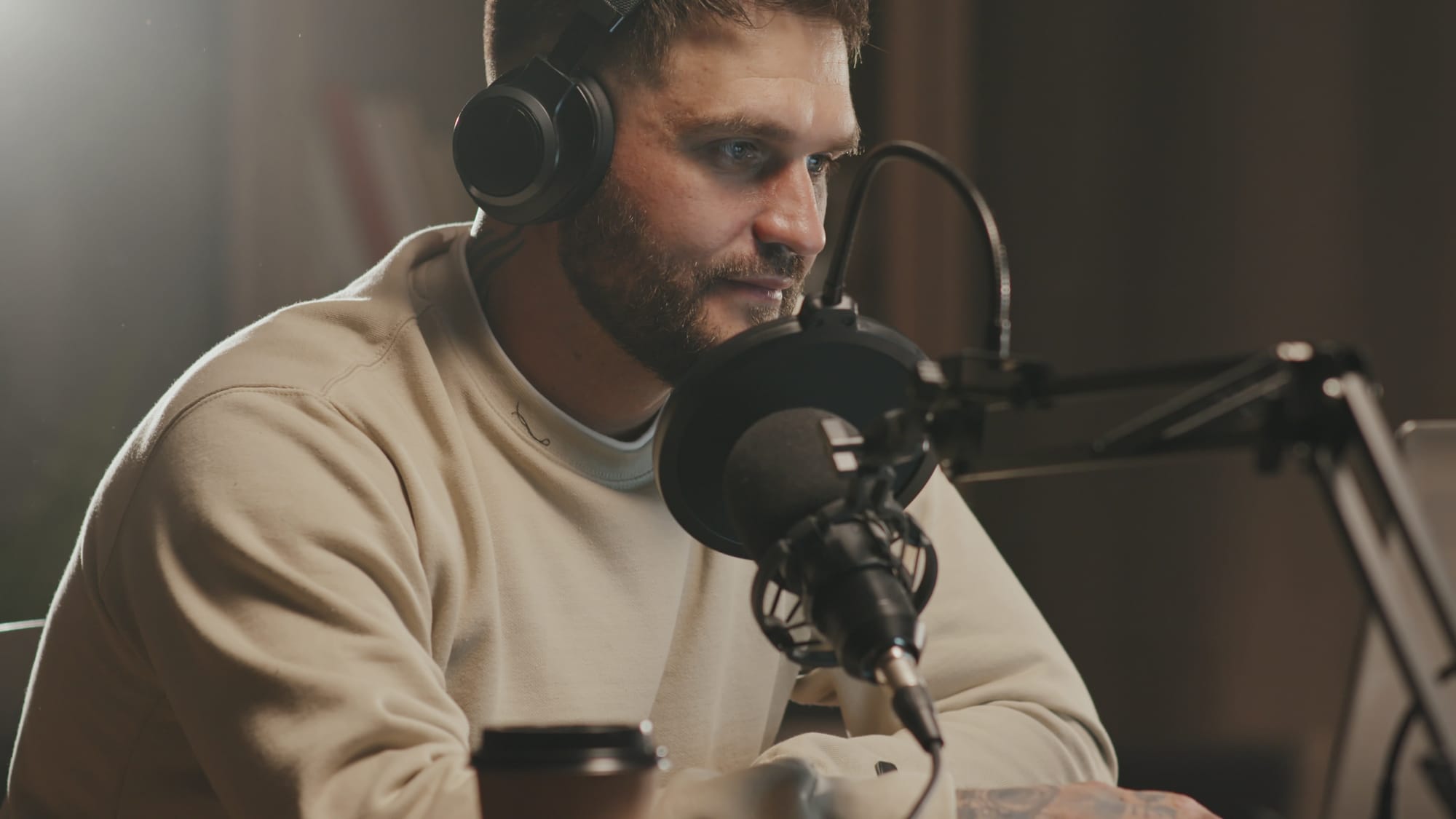 A man with a microphone recording a podcast.