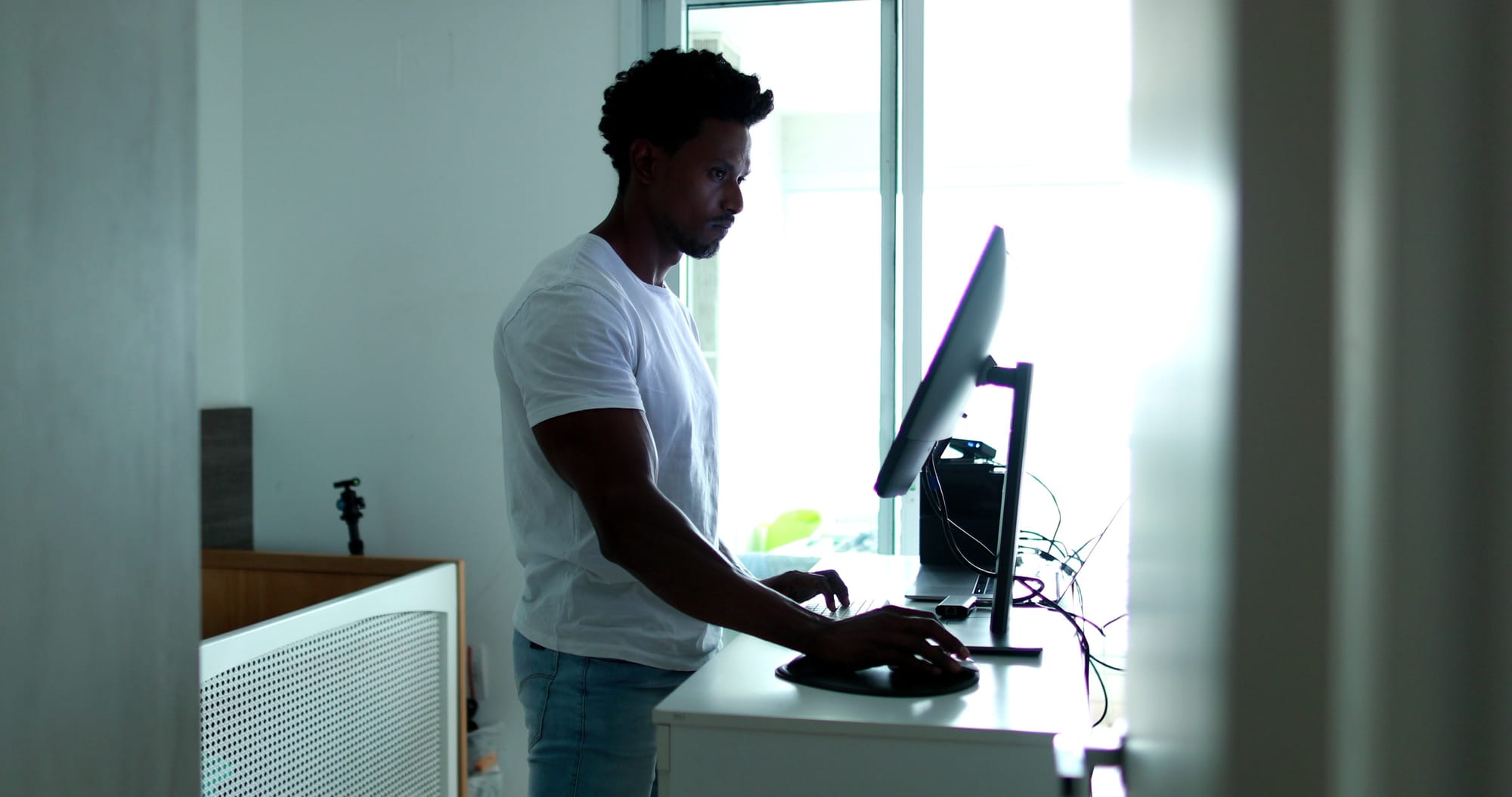 A man stands at a computer.