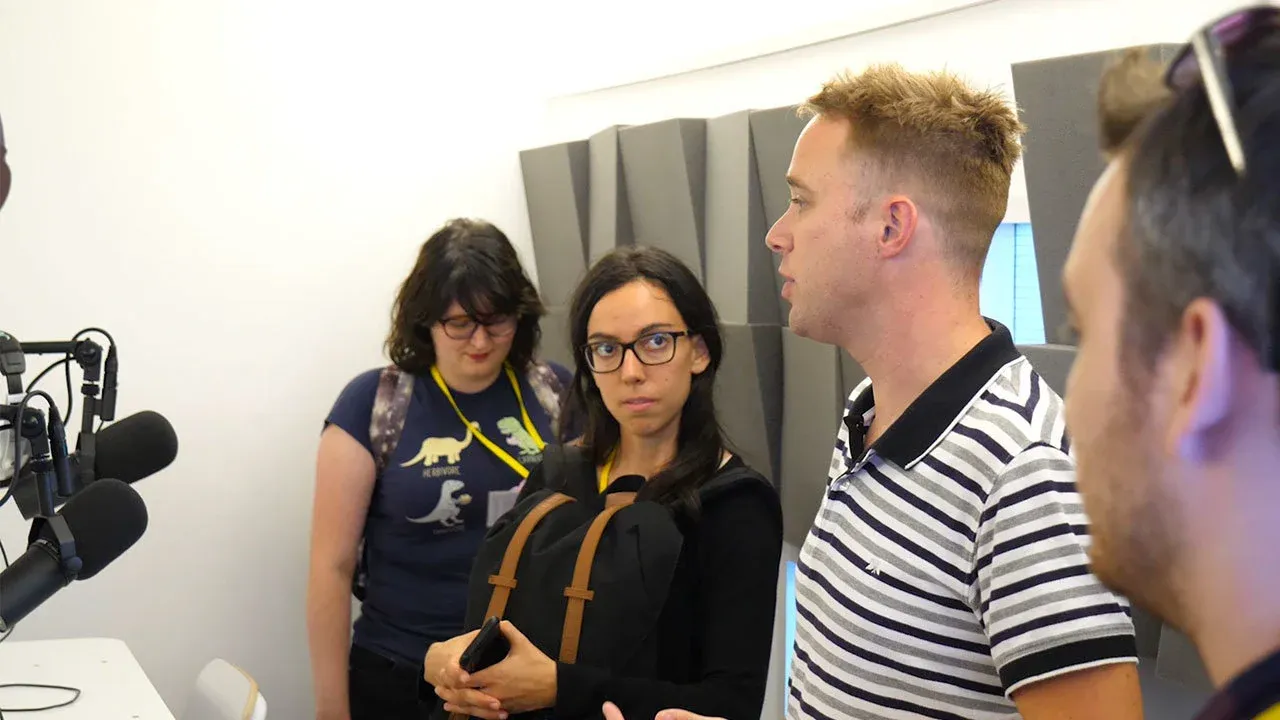 A group of people standing around a set of microphones.