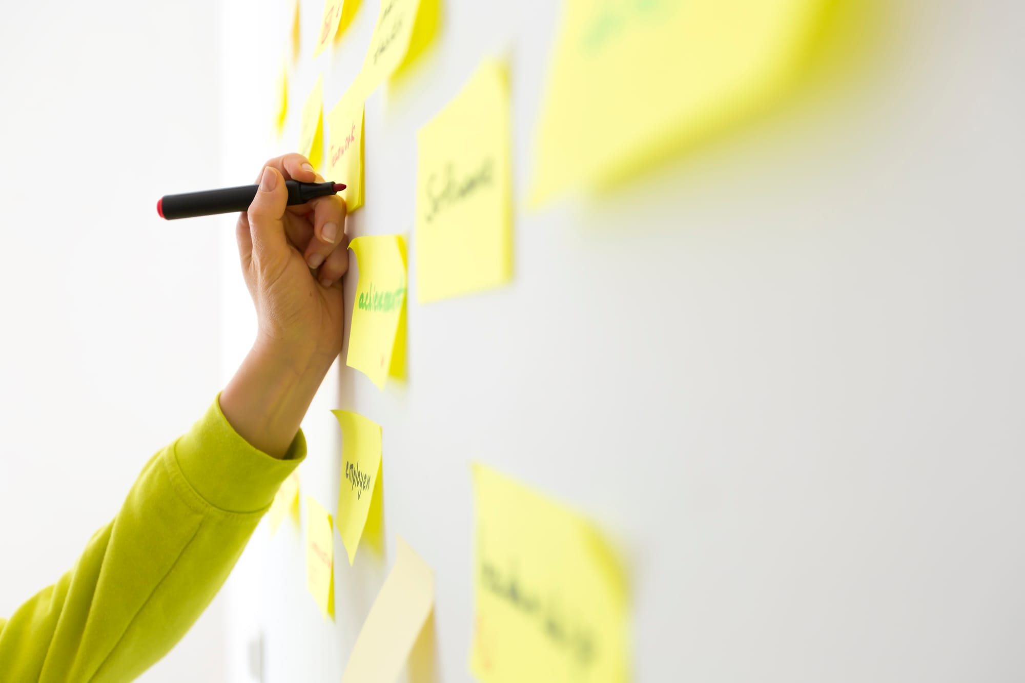 Person writing on sticky notes
