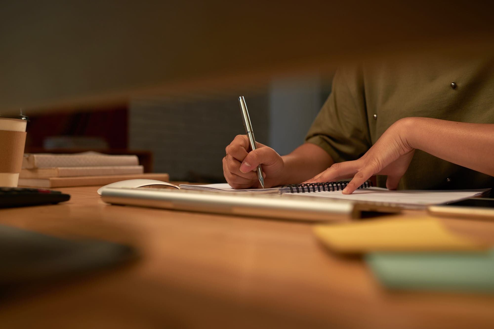 Person writing notes in a notebook